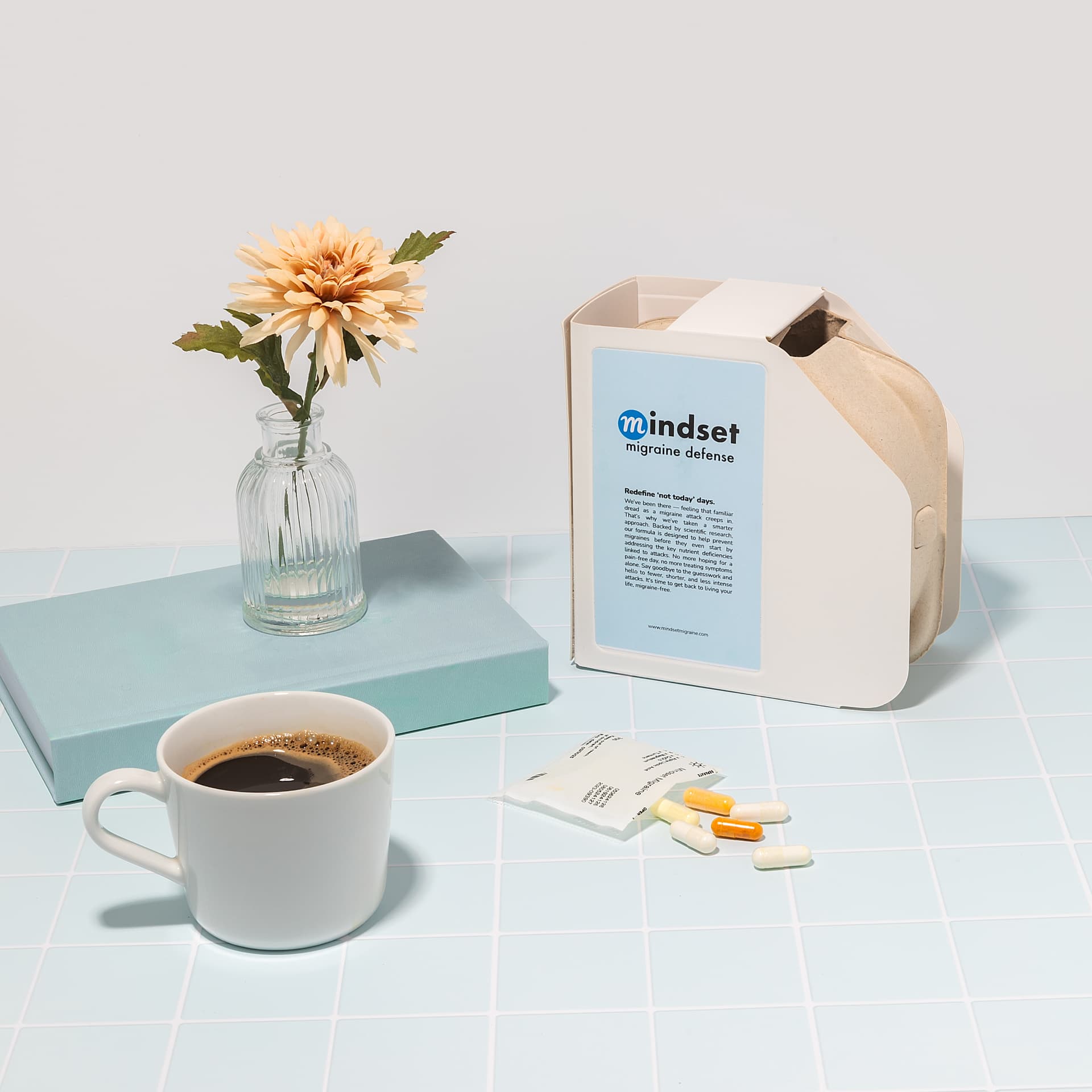 Mindset product pack, daily pouch and capsules beside a cup of coffee